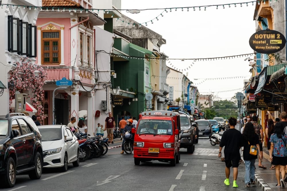 Old Phuket Town with tuk-tuk, cars, and pedestrians on the street