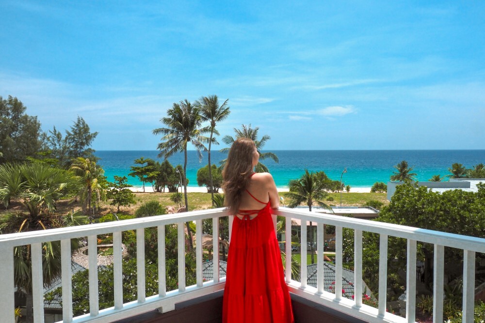 Woman on a balcony overlooking Thavorn Palm Beach resort