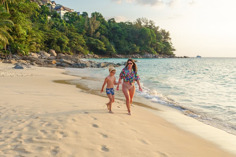 A mother and son walk together on a beautiful Phuket beach